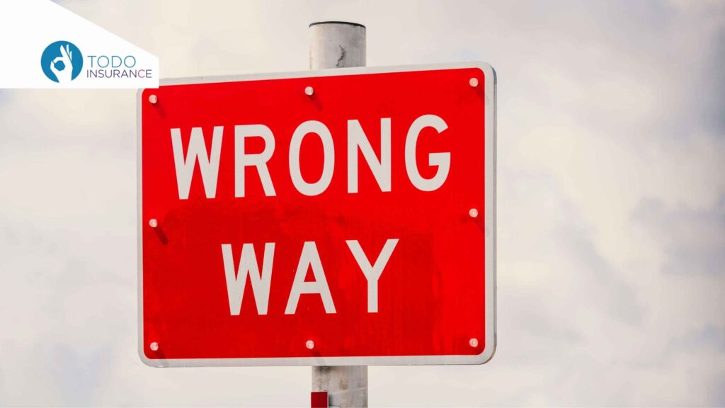 A red rectangular road sign that reads "WRONG WAY" in bold white capital letters against a cloudy sky. The "TODO INSURANCE" logo is positioned in the top left corner how to apply for Obamacare