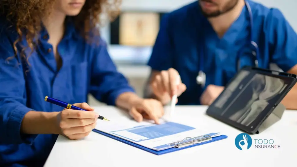 médico explicando un formulario a una mujer, frente a una tablet con una radiografía que es obama care todo insurance