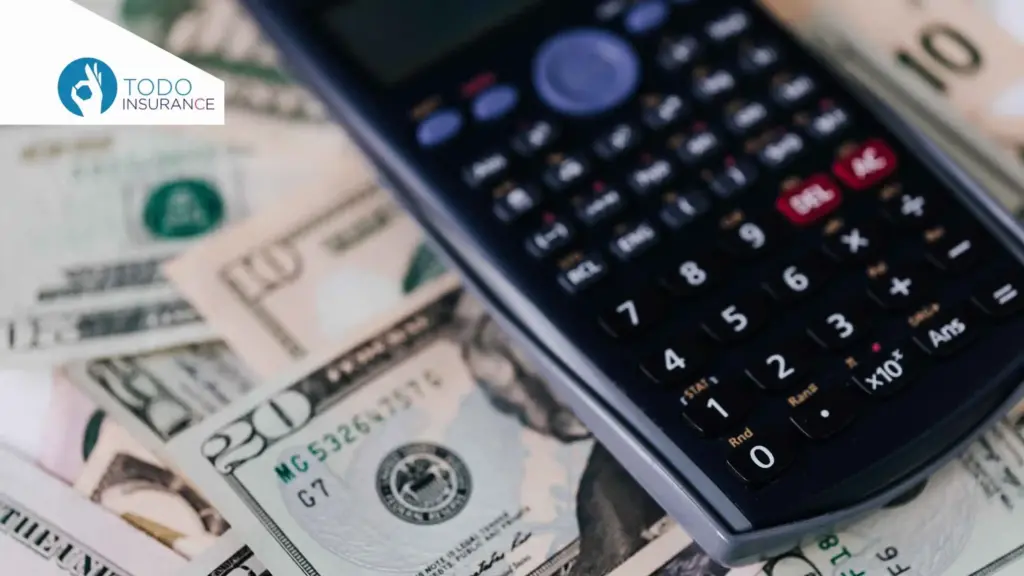 A smartphone placed on top of several U.S. dollar bills of different denominations ACA Plan Tiers todo insurance