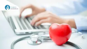 A person typing on a computer in the background, with a stethoscope and a heart-shaped stress ball in the foreground obamacare open enrollment todo insurance